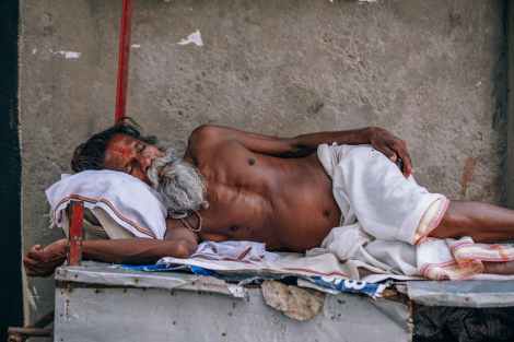 man wearing white shorts lying on wooden bed